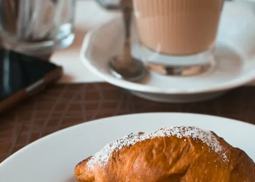Café et croissant sur une table de boulangerie